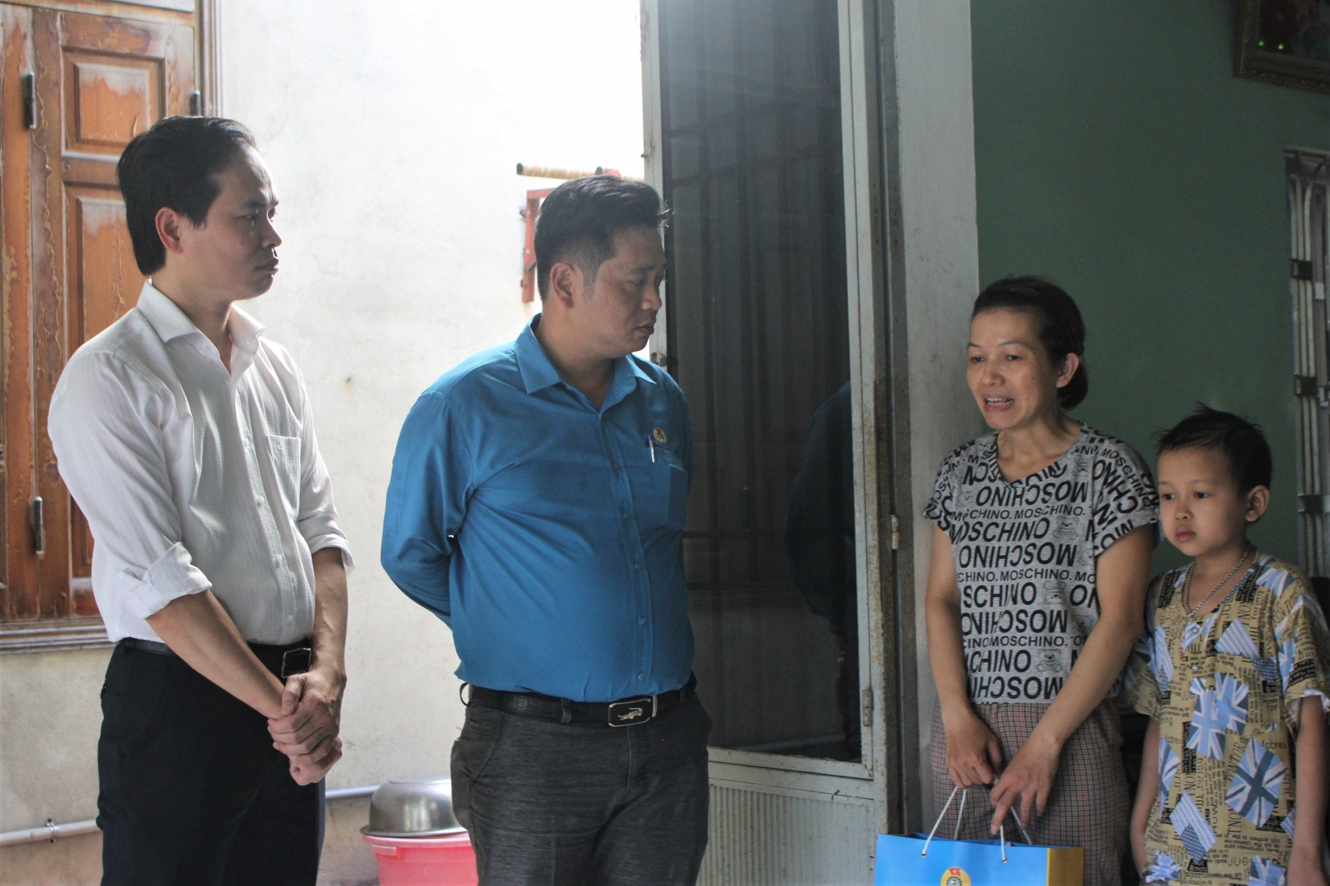 Đồng chí Nguyễn Duy Minh, Chủ tịch LĐLĐ TP Đà Nẵng (bìa trái) đến thăm, động viên gia đình chị Nguyễn Thị Minh Tâm. Ảnh HẢI ĐỊNH
