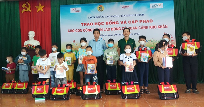 Con công nhân lao động vui mừng khi nhận được học bổng từ công đoàn