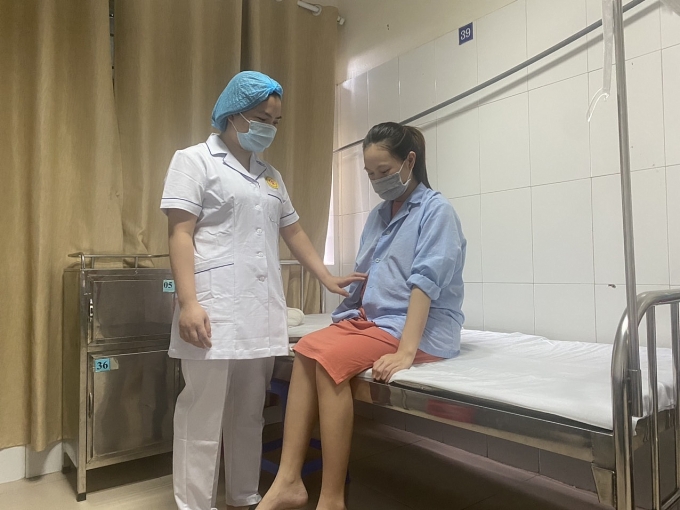 Y tá đang chăm sóc và hỏi han tình hình cho nữ công nhân Xỏn. Ảnh: HẢI YẾN