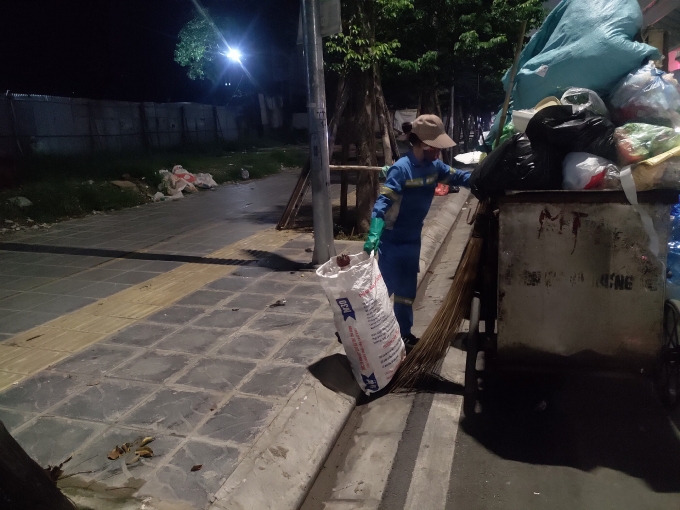 Gần 12 giờ đêm nhưng người phụ nữ ấy vẫn đang miệt mài với công việc phân loại và thu gom rác sinh hoạt. Ảnh: M.A Gần 12 giờ đêm nhưng người phụ nữ ấy vẫn đang miệt mài với công việc phân loại và thu gom rác sinh hoạt. Ảnh: M.A