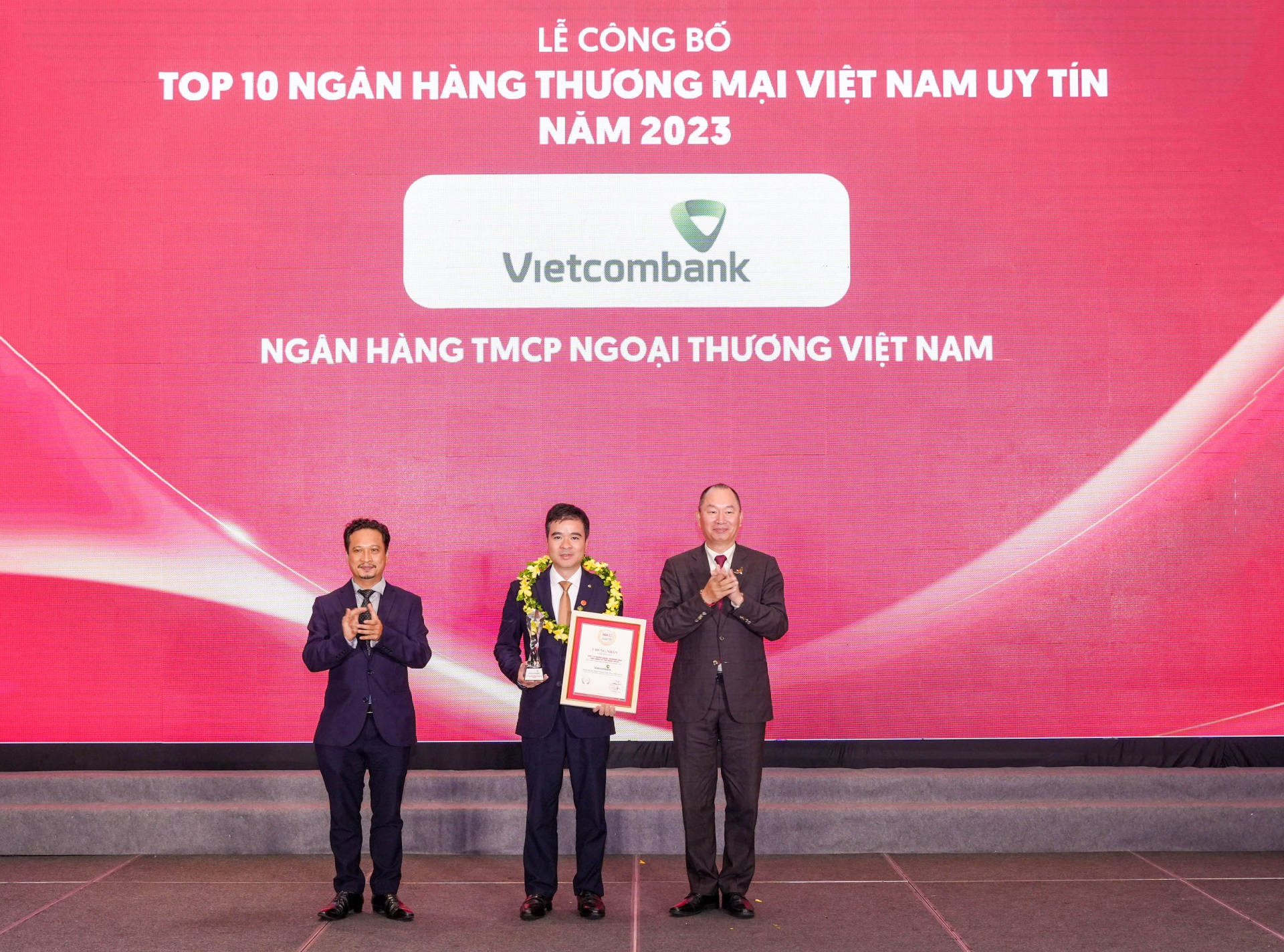 Đại diện Vietcombank (đứng giữa) nhận danh hiệu “Ngân hàng uy tín nhất Việt Nam năm 2023” từ Ban Tổ chức
