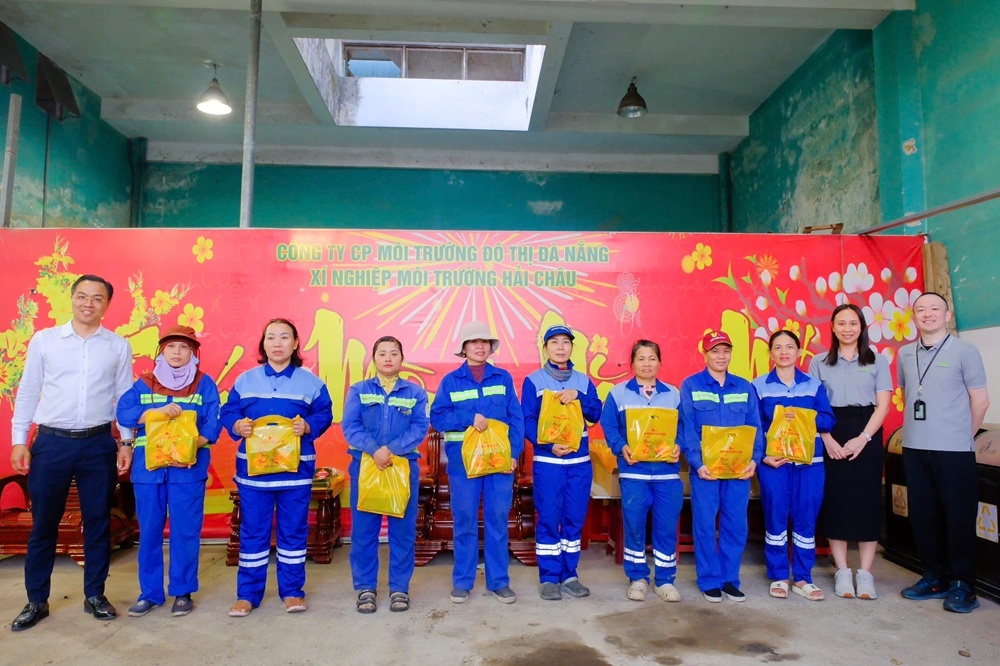 Giám đốc Nhà văn hóa Lao động thành phố Đà Nẵng Trần Ngọc Anh (áo trắng) cùng mạnh thường quân trao bánh chưng cho công nhân lao động.