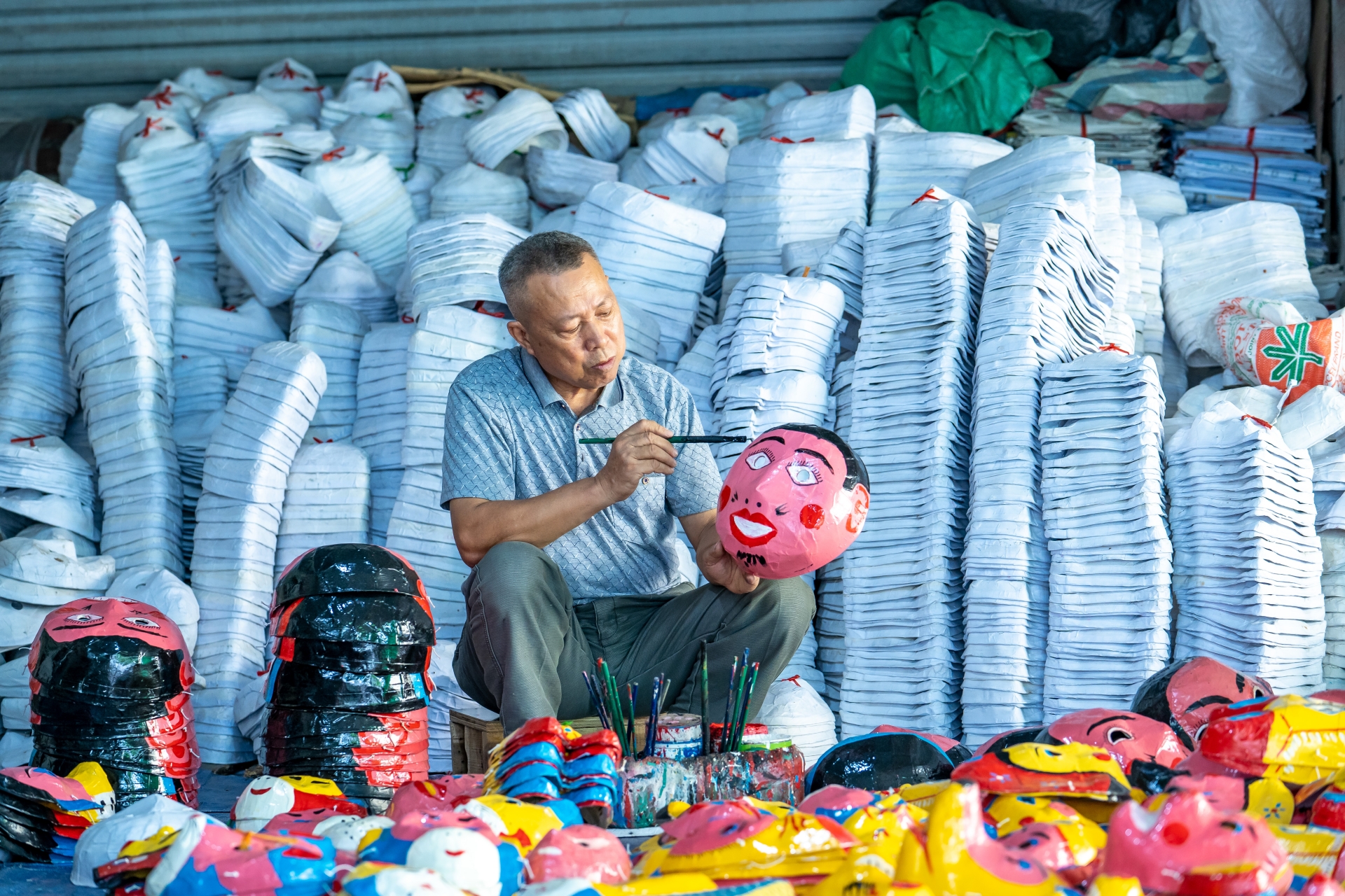 Những người thợ bên trong vẫn đang tất bật sản xuất trống, nhưng nhiều nhất là mặt nạ giấy bồi để có thể kịp thời cung cấp mặt hàng đậm nét văn hóa dâ